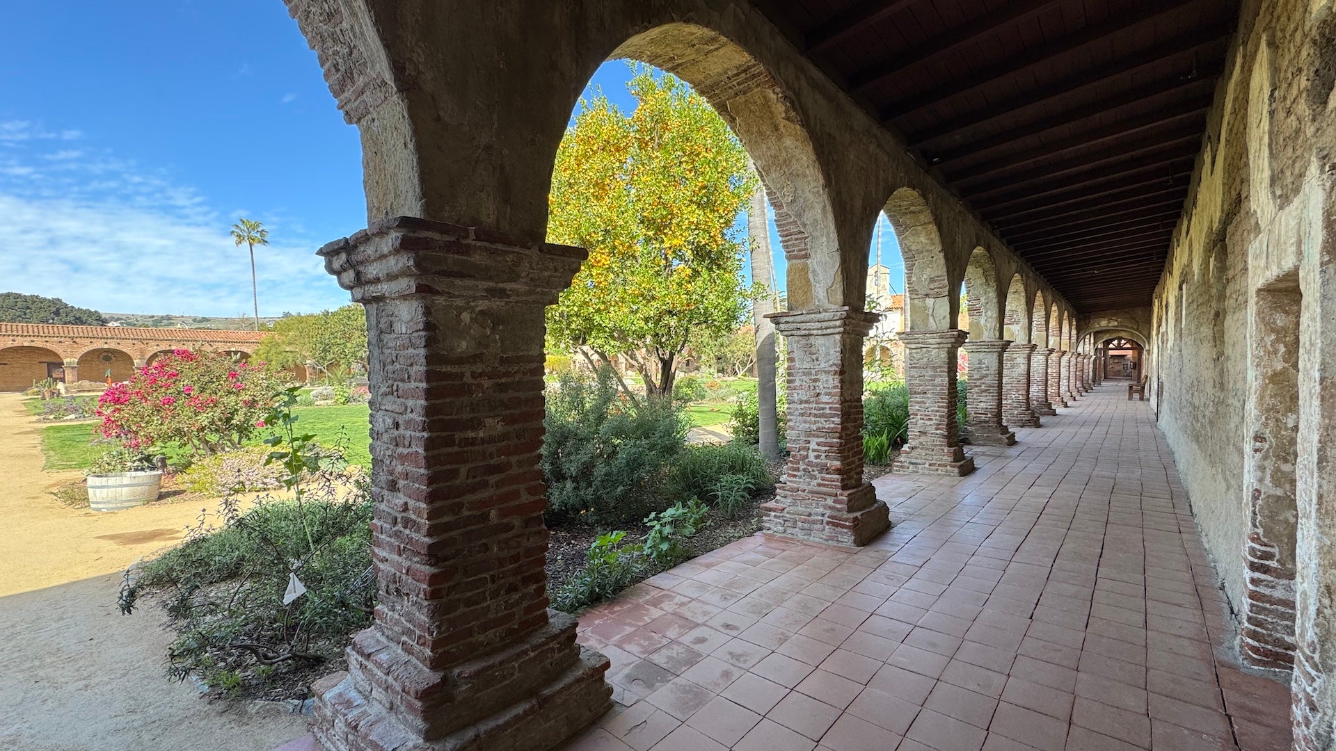 Stone cloisters and a garden courtyard at the mission in - San Juan Capistrano, CA